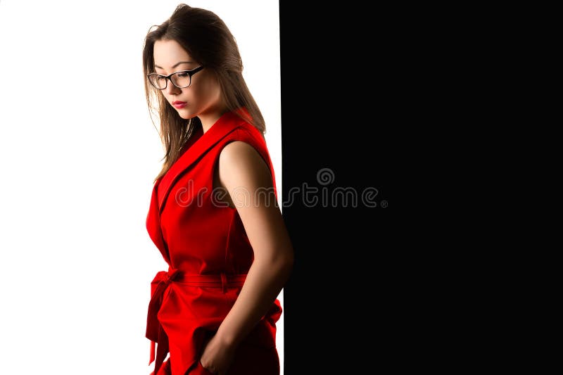 Peinzende charmante bedrijfsvrouw in rood kostuum