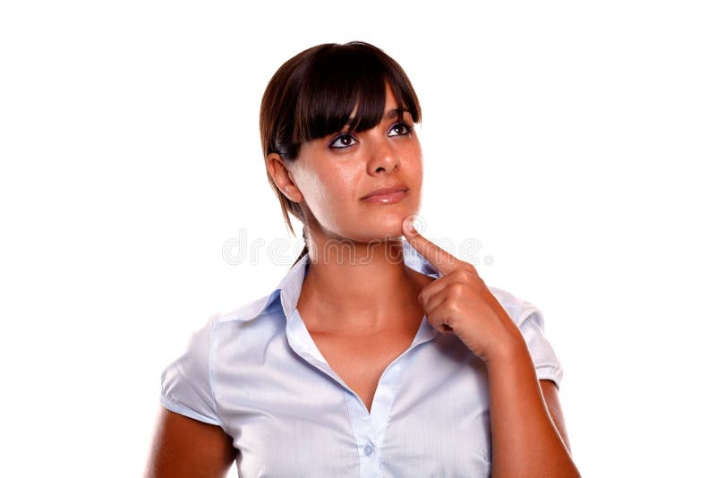 Pensive hispanic young woman looking up on blue blouse against white background - copyspace. Pensive hispanic young woman looking up on blue blouse against white background - copyspace