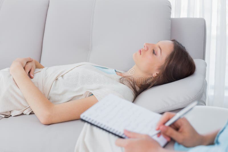 Peinzende vrouw die op de laag liggen terwijl psycholoog het schrijven stock afbeeldingen Peinzende vrouw die op de laag liggen terwijl psycholoog het schrijven stock afbeeldingen