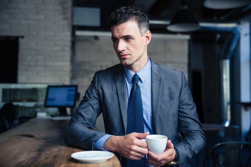 Peinzende zakenman het drinken koffie in koffie stock afbeelding Peinzende zakenman het drinken koffie in koffie stock afbeelding