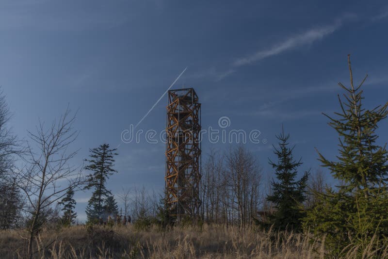 Pekelsky hill with observation tower and flying airplane and blue sky