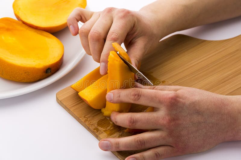 Pelare la carne della frutta dalla pelle del mango fotografia stock Pelare la carne della frutta dalla pelle del mango fotografia stock
