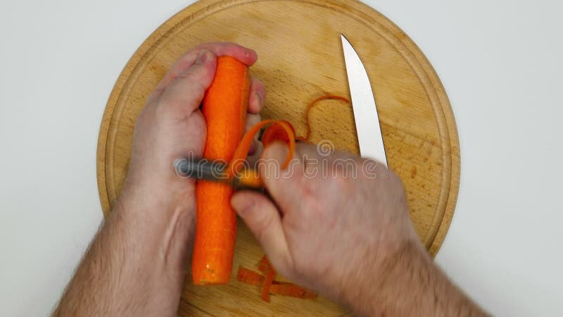 Pelatura Della Carota. Le Mani Di Un Maschio Pelano Le Carote D'arancia  Fresche Con Un Coltello E Un Olio Di Verdura Archivi Video - Video di  chiusura, isolato: 275103255