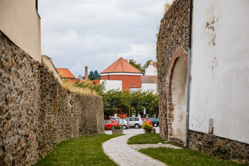 Pelhrimov, Czech Republic, 03 July 2021: narrow picturesque street with stone ancient fortress walls at summer day in center of