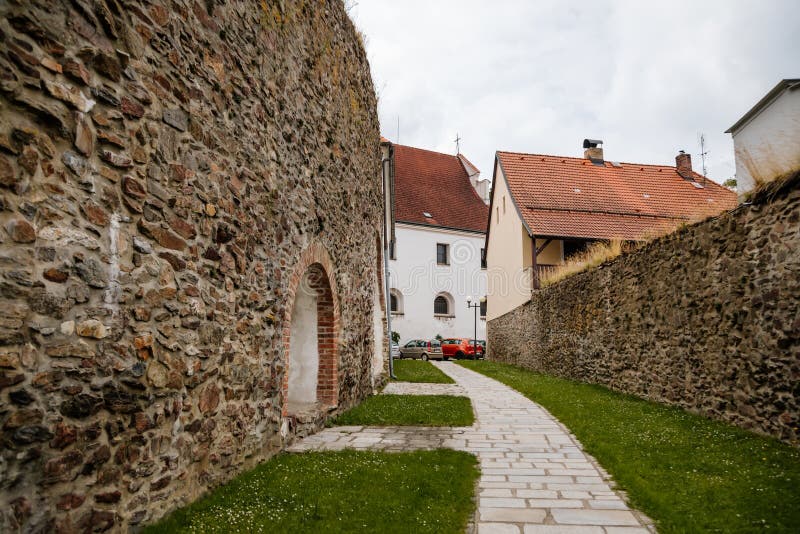 Pelhrimov, Czech Republic, 03 July 2021: narrow picturesque street with stone ancient fortress walls at summer day in center of