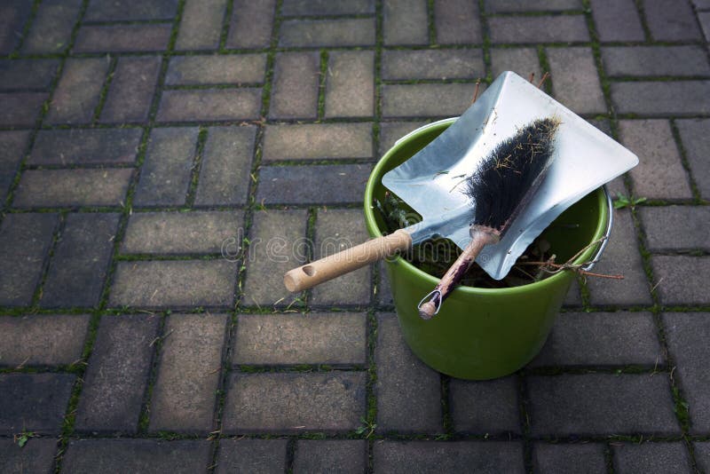 Dustpan, brush and green bucket outside on pavement. Dustpan, brush and green bucket outside on pavement