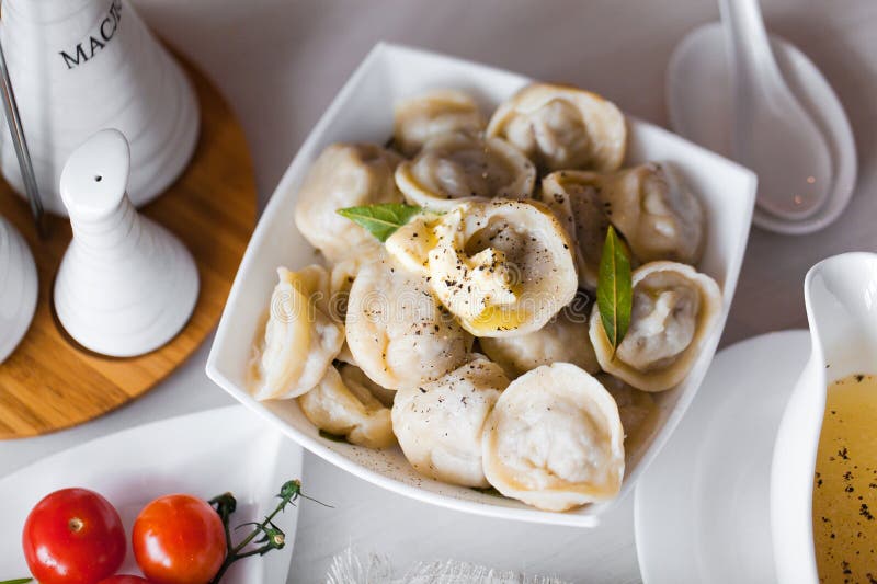 Russian pelmeni (meat dumplings) with sour cream and dill. Russian pelmeni (meat dumplings) with sour cream and dill