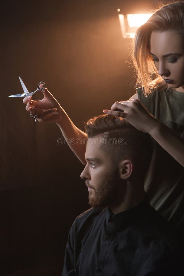 Pelo masculino del inconformista del corte femenino del peluquero fotografía de archivo Pelo masculino del inconformista del corte femenino del peluquero fotografía de archivo