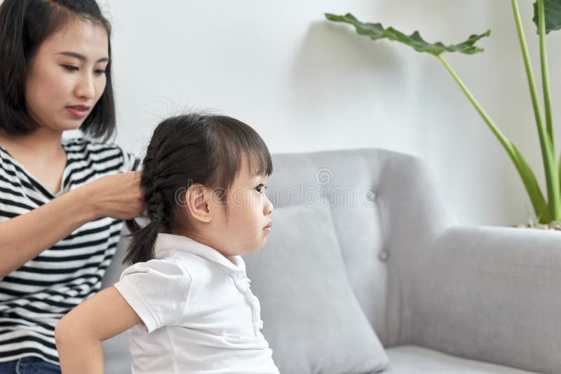 Pelo que trenza de la madre de su hija imágenes de archivo libres de regalías Pelo que trenza de la madre de su hija imágenes de archivo libres de regalías