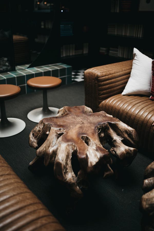 Pelone di lancio bianco su un divano marrone vicino al tavolo da caffè decorativo e sgabelli da bar vuoti fotografia stock Pelone di lancio bianco su un divano marrone vicino al tavolo da caffè decorativo e sgabelli da bar vuoti fotografia stock