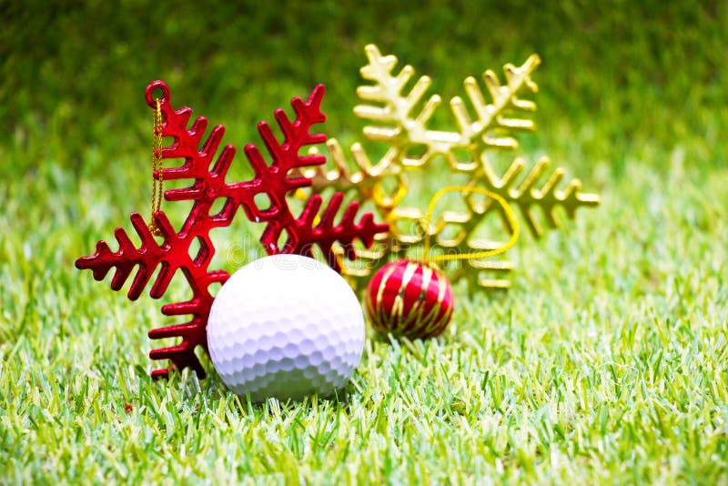 Golf ball with Christmas ornament on green grass. Golf ball with Christmas ornament on green grass