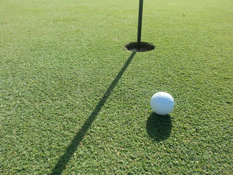 Golf Ball on the Putting Green very close to the hole. Golf Ball on the Putting Green very close to the hole.