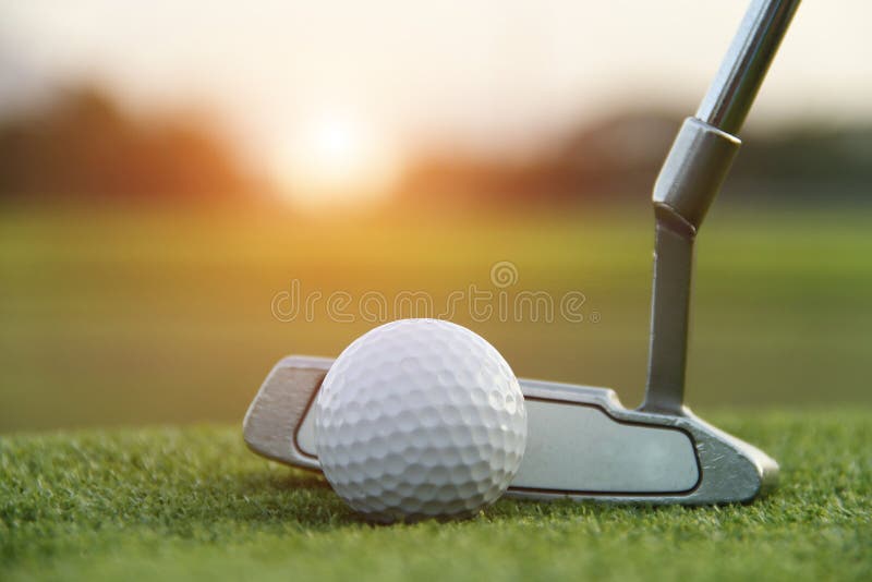 Pelota de golf y club de golf en campo de golf hermoso en el fondo de la puesta del sol imagen de archivo libre de regalías Pelota de golf y club de golf en campo de golf hermoso en el fondo de la puesta del sol imagen de archivo libre de regalías