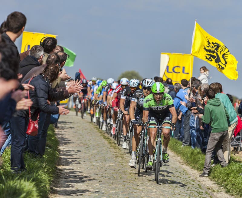 Carrefour de l'Arbre,France-April 13,2014: The peloton riding on the famous cobblestone sector Carrefour de l'Arbre in Camphin-en-Pévèle town during the 2014 edition of Paris-Roubaix cycling race. Carrefour de l'Arbre,France-April 13,2014: The peloton riding on the famous cobblestone sector Carrefour de l'Arbre in Camphin-en-Pévèle town during the 2014 edition of Paris-Roubaix cycling race.