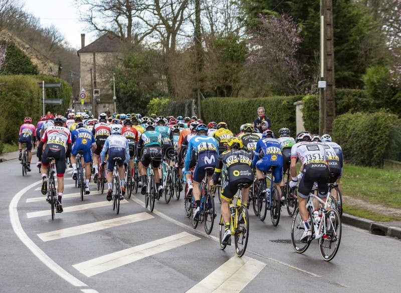 Beulle, France - March 10, 2019: Rear view of the peloton riding on Cote de Beulle during the stage 1 of Paris-Nice 2019. Beulle, France - March 10, 2019: Rear view of the peloton riding on Cote de Beulle during the stage 1 of Paris-Nice 2019