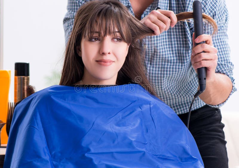 Peluquero de sexo masculino del hombre que hace el corte de pelo para la mujer imágenes de archivo libres de regalías Peluquero de sexo masculino del hombre que hace el corte de pelo para la mujer imágenes de archivo libres de regalías