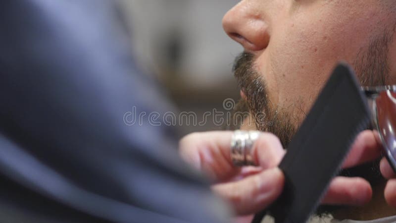 Peluquero que afeita cierre barbudo del inconformista para arriba