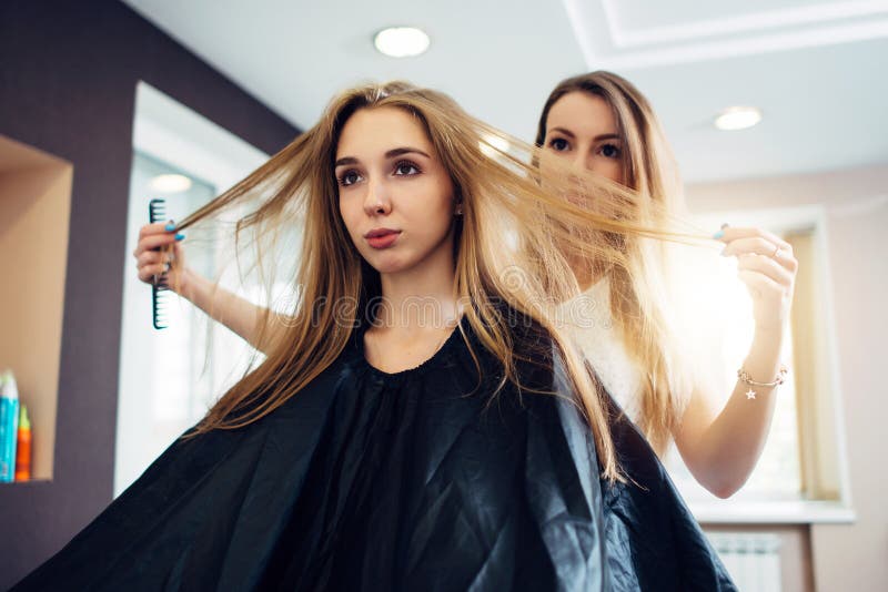 Peluquero y cliente que discuten, decisión, eligiendo cómo cortar el pelo en salón de la peluquería fotografía de archivo Peluquero y cliente que discuten, decisión, eligiendo cómo cortar el pelo en salón de la peluquería fotografía de archivo