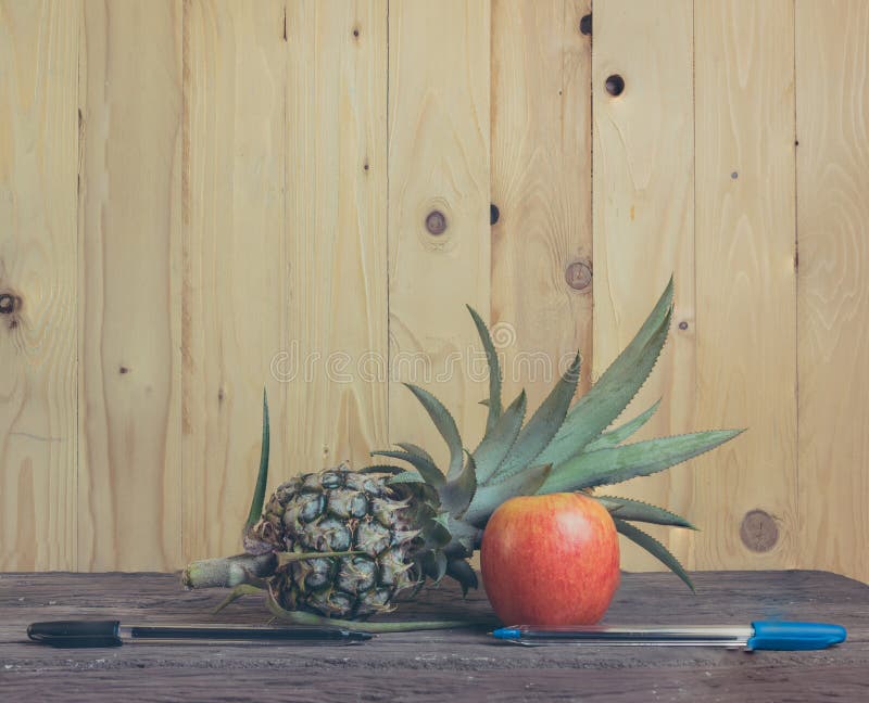 Pen-ananas-Apple-pen op houten achtergrond royalty-vrije stock afbeelding Pen-ananas-Apple-pen op houten achtergrond royalty-vrije stock afbeelding