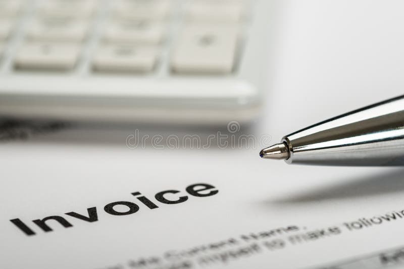Close-up Of Pen With Calculator Over Invoice Paper. Close-up Of Pen With Calculator Over Invoice Paper