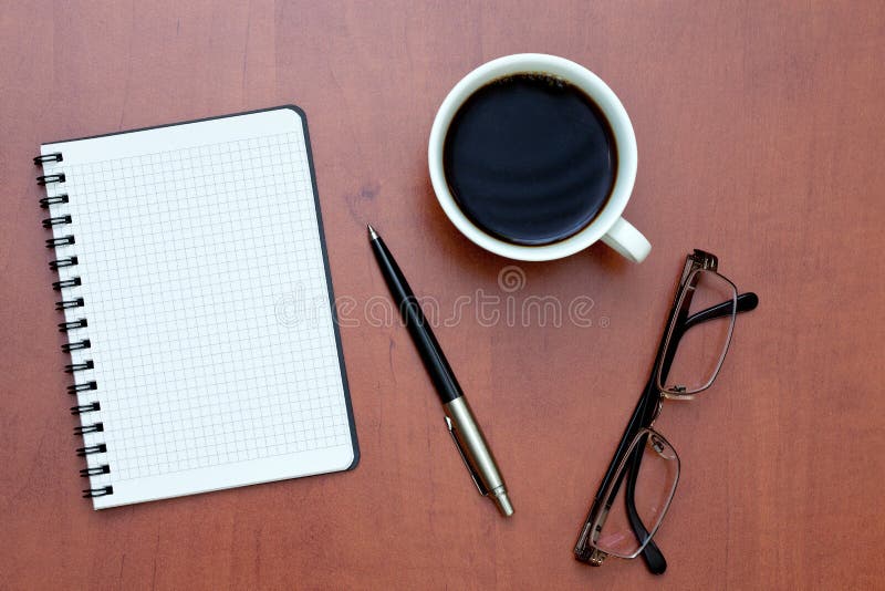 Pen, notebook and glasses with coffee