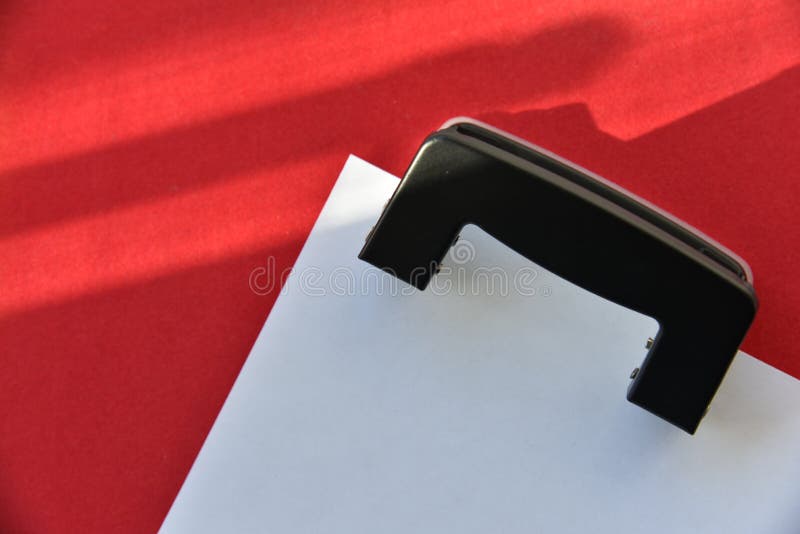 Pencils hole punch and notepad on a red background royalty free stock photos