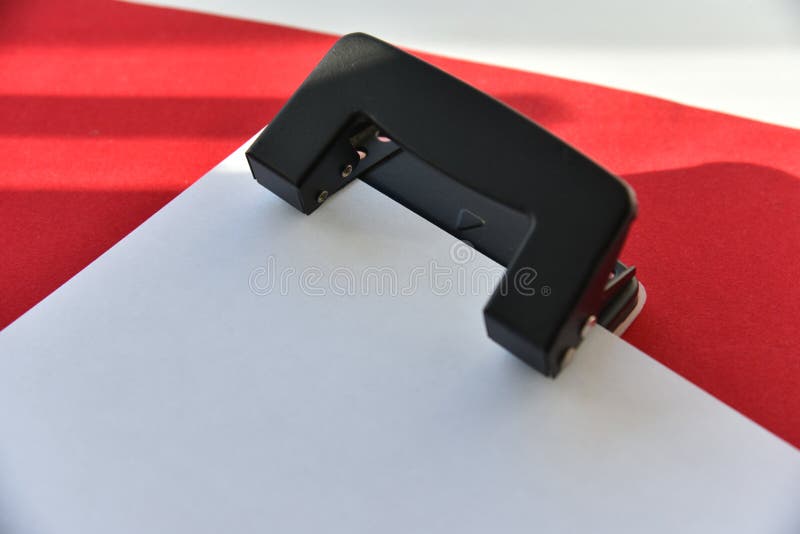 Pencils hole punch and notepad on a red background royalty free stock images