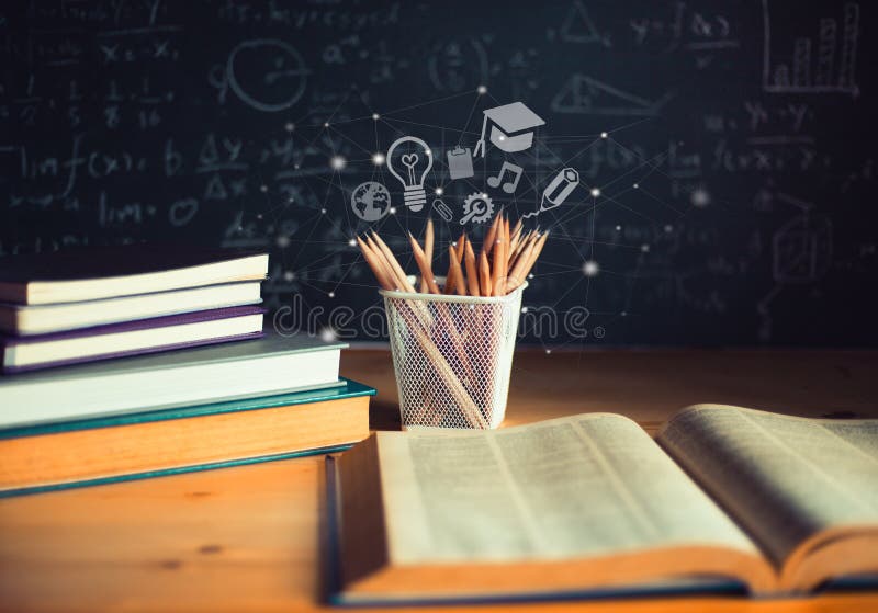 Pencils and Open books with formulas on the chalkboard .education concept