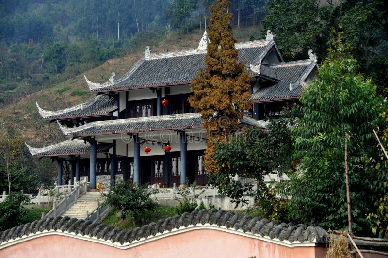 The small Ge Xian Guan Taoist Temple with its distinctive flying-eaved roofs nestles against the side of a hill in a Sichuan province mountain valley near the city of Pengzhou, China. The small Ge Xian Guan Taoist Temple with its distinctive flying-eaved roofs nestles against the side of a hill in a Sichuan province mountain valley near the city of Pengzhou, China.