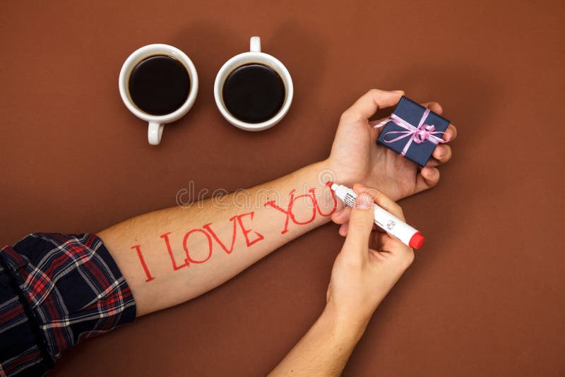 Pennan skriver den dyrt röda bokstaven mig älskar dig dagen för ` s för valentin för brunt för asken för gåvan för handkaffekoppe arkivfoton Pennan skriver den dyrt röda bokstaven mig älskar dig dagen för ` s för valentin för brunt för asken för gåvan för handkaffekoppe arkivfoton