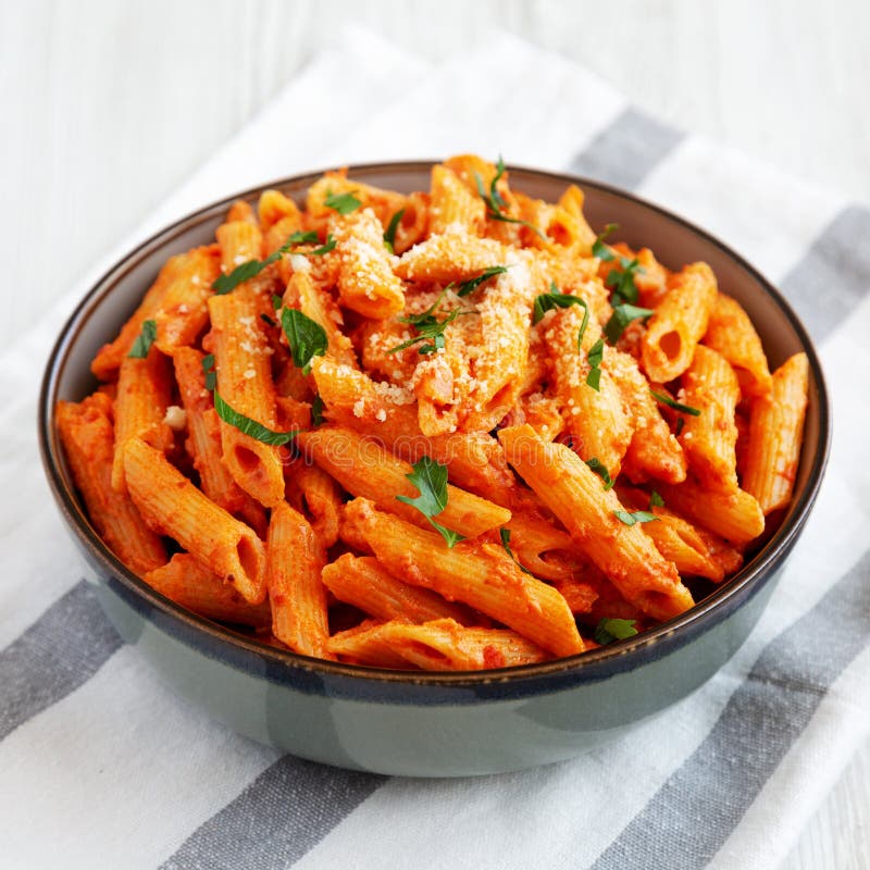 Penne alla vodka ottenuta da salsa in sospensione con vista sul formaggio e prezzemolo immagine stock