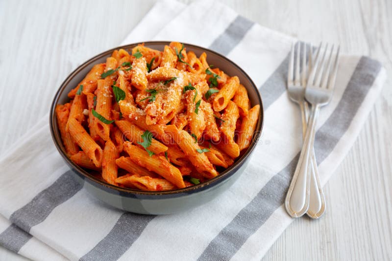 Penne alla vodka ottenuta da salsa in sospensione con vista sul formaggio e prezzemolo immagine stock