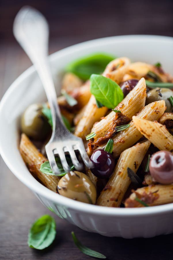 Penne with dried tomato pesto, olives and herbs