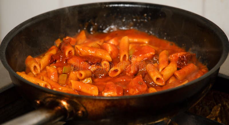 Penne makaronu kucharstwo w świeżym domowej roboty pomidorowym kumberlandzie z zucchini i słońcem suszył pomidory - Istny karmowy fotografia royalty free Penne makaronu kucharstwo w świeżym domowej roboty pomidorowym kumberlandzie z zucchini i słońcem suszył pomidory - Istny karmowy fotografia royalty free