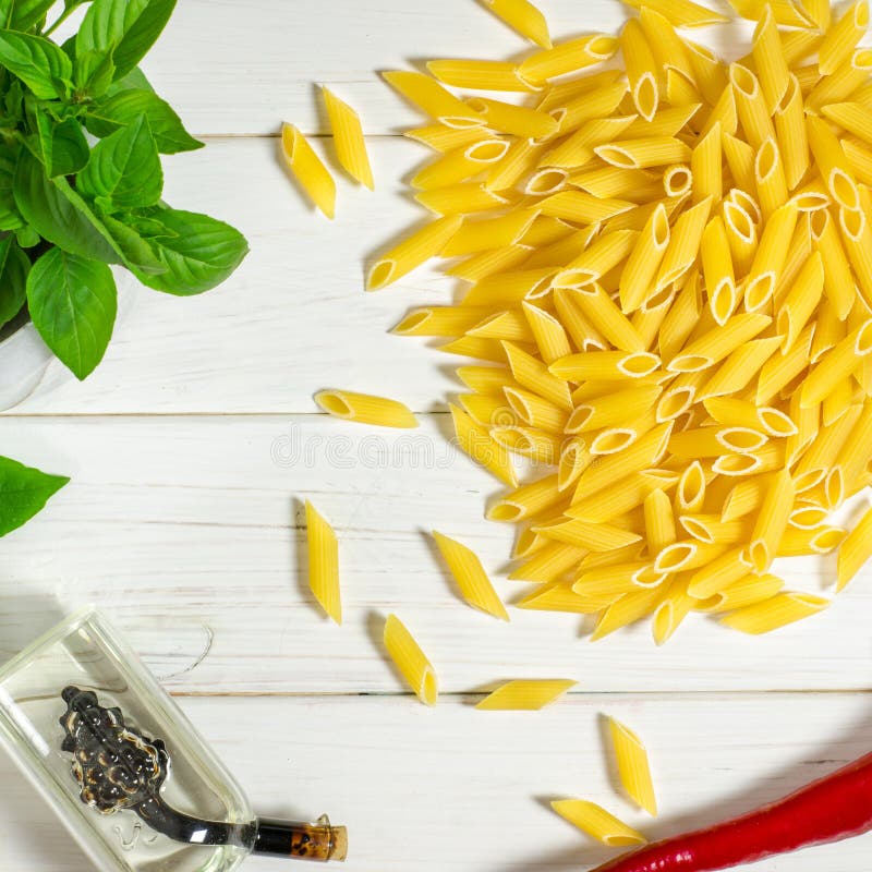 Penne Pasta, grüne Basilika, Parmesan, Sesam, Knoblauch, Chili, Eier liegen auf einem weißen Tisch lizenzfreies stockfoto