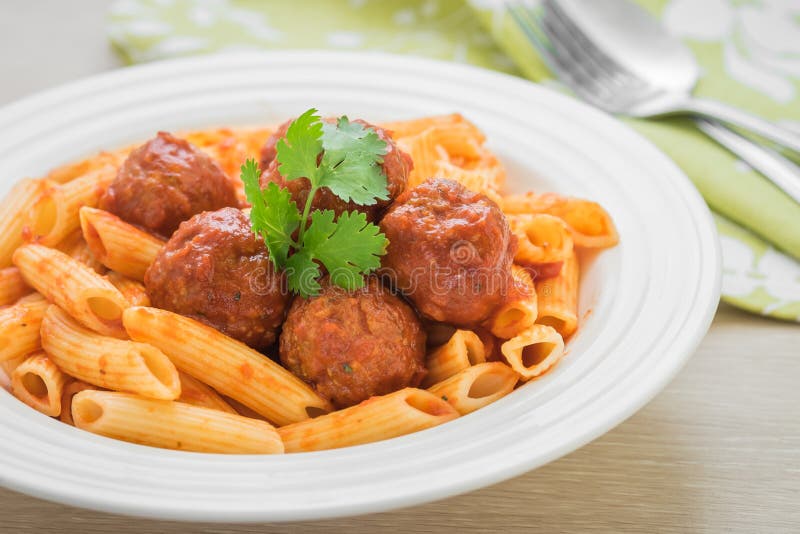 Penne pasta with meatballs in tomato sauce on plate