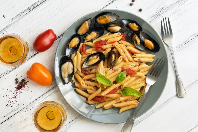 Penne Pasta with Mussels, Tomatoes and White Wine on a White Wooden ...
