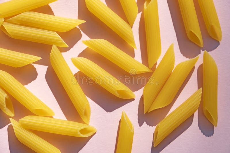 Penne Rigate Pasta Pile on Pastel Pink Surface. Cute Shape of Raw, Uncooked  Pasta on Blight Pink Background. Stock Image - Image of flower, calories:  283169219