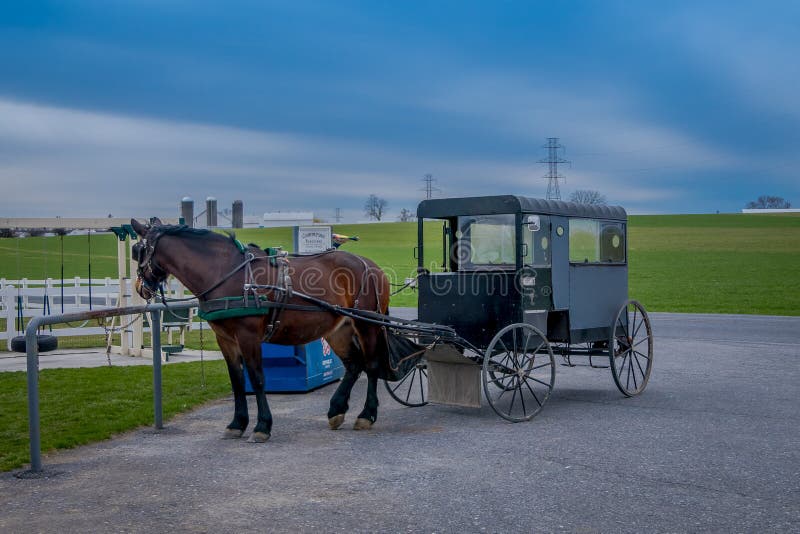 Pennsylvania, USA, APRIL, 18, 2018: Outdoor view of parked Amish buggy carriage in a farm with a horse used for a pull royalty free stock image Pennsylvania, USA, APRIL, 18, 2018: Outdoor view of parked Amish buggy carriage in a farm with a horse used for a pull royalty free stock image