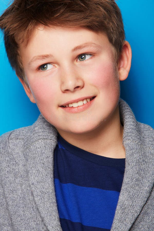 Pensamiento infantil y fondo azul con estilo joven de moda y ropa de moda en un estudio. niño pequeño y sonrisa fotografía de archivo libre de regalías