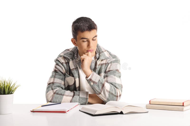 Pensionierter junger Mann sitzt an einem Schreibtisch und sieht Bücher an lizenzfreie stockfotografie