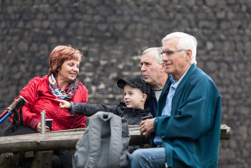 Pensionärer och barnet på familjen snubblar att vila utomhus royaltyfri foto Pensionärer och barnet på familjen snubblar att vila utomhus royaltyfri foto