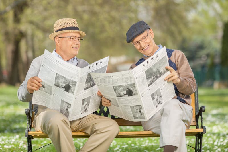 Pensionärer som läser tidningen i en parkera