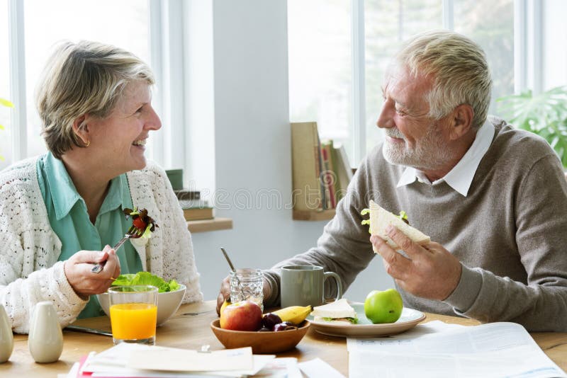 Pensionäråldringpar som äter frunchbegrepp