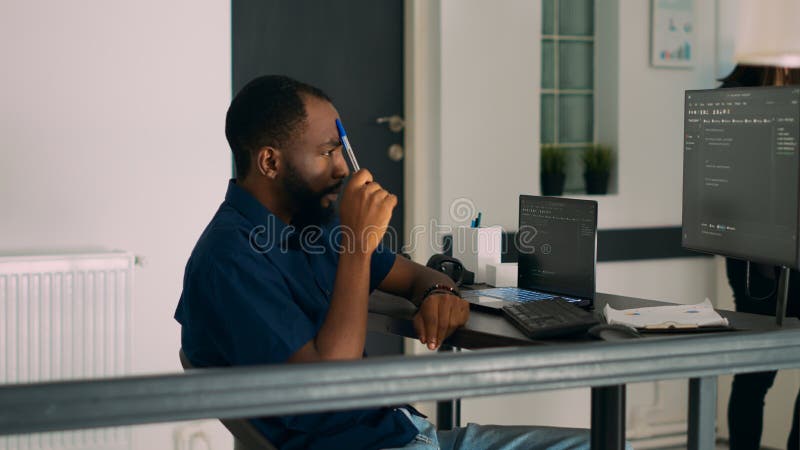 Pensive african american programer working on code development stock images