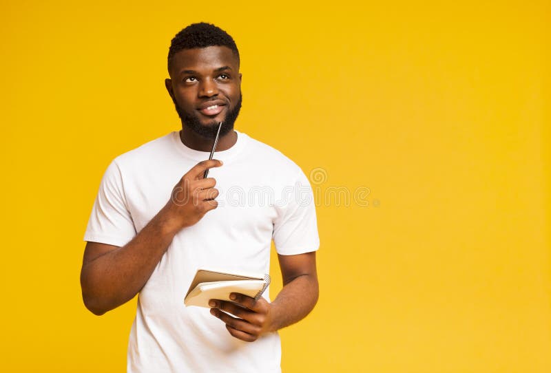 Pensive african guy neemt notities, schrijft een checklist in notitieboekje stock fotografie Pensive african guy neemt notities, schrijft een checklist in notitieboekje stock fotografie