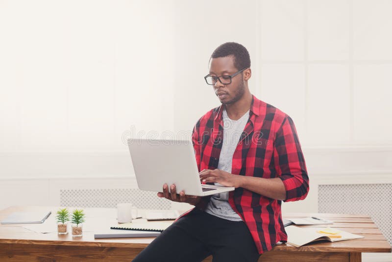 Pensive black businessman in casual office, work with laptop royalty free stock photo Pensive black businessman in casual office, work with laptop royalty free stock photo