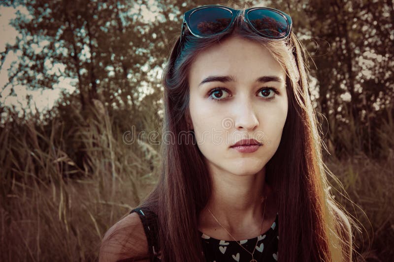 Pensive face of a girl in nature stock photo Pensive face of a girl in nature stock photo