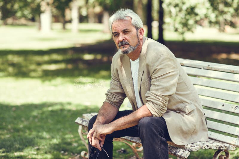 Pensive Mature Man Sitting on Bench in an Urban Park. Stock Photo ...