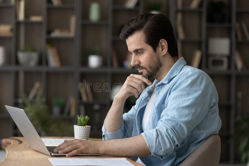 Pensive Caucasian man work on computer thinking royalty free stock images